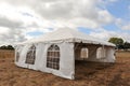 White tents in a dry field outdoors