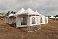 White tents in a dry field outdoors