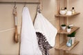 White terry towel, brush and bathrobe hanging on rack in bathroom Royalty Free Stock Photo