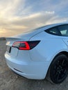 White Tesla model 3 parked outdoors at sunset