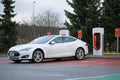 White Tesla Model S being Charged at Supercharger Station