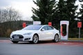 White Tesla Model S being Charged at Supercharger Station