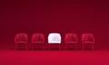 White Textile Chair That Stands Out From the Red Leather Chairs Crowd on a Viva Magenta Studio Background. Royalty Free Stock Photo