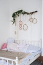 White textured bedroom in the style of shabby. Bed in an ecological style and Loft style. Rustic dream catchers on a white wall. Royalty Free Stock Photo