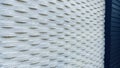 White textured wall with horizontal wave patterns contrasting sharply with a dark, vertical panel Royalty Free Stock Photo
