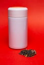 white thermo mug with green leaf tea on a red background. Royalty Free Stock Photo