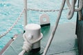 Rope lies on boat mooring bollard near pier against water Royalty Free Stock Photo