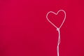 White thread in heart shape on red fabric background love and romance concept Royalty Free Stock Photo