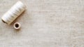 white thread spools on linen neutral textured background with generous copy space at right, topleft arrangement Royalty Free Stock Photo