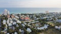 White three-story vacations homes, condo buildings surrounding by lush green trees in beach neighborhood along county road 30A, Royalty Free Stock Photo