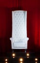 White throne on a red background, chair with high back, elevated position
