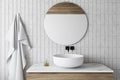 White tile bathroom with sink and round mirror