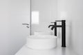 White tiled bathroom with two wash basins and black faucets Royalty Free Stock Photo