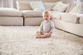 White toddler boy sitting on the floor in sitting room Royalty Free Stock Photo