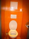 White toilet in a lovely orange toilet room