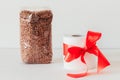 White toilet paper with a red bow on a white background. Buckwheat