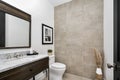 White toilet and a white sink against a tiled wall in a bathroom,