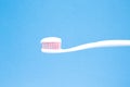 White toothbrush with toothpaste on blue background Royalty Free Stock Photo