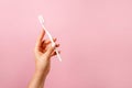 White Toothbrush in woman's hand on pink background with copy space Royalty Free Stock Photo