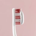 white toothpaste on a toothbrush, pink background Royalty Free Stock Photo