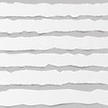 White torn blank horizontal note paper strips for text or message stuck on gray background with shadows. Royalty Free Stock Photo