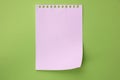 White torn sheet of notebook on light green background, top view.