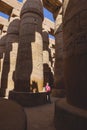 White Tourist looking at the Ancient Massive Columns of Karnak Temple Complex in the Great Hypostyle Hall in the Precinct of Amun- Royalty Free Stock Photo