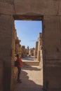 White Tourist looking at the Ancient Massive Columns of Karnak Temple Complex in the Great Hypostyle Hall in the Precinct of Amun- Royalty Free Stock Photo
