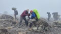 A white tourist shows his black friend how to take pictures with a camera. Climbing Kilimanjaro, Africa