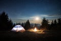 Magical nightfall view of starry sky over campsite in the mountains.