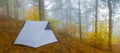 White touristic tent stay on mount slope in dense mist