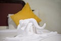 White towel in elephant shape on white bed in hotel Royalty Free Stock Photo