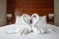 The white towel folded into a swan shape. Placed together in a heart shape on the bed. Royalty Free Stock Photo