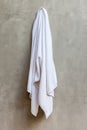 White towel is hanging on the exposed concrete wall in the bathroom Royalty Free Stock Photo