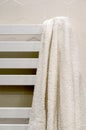A white towel hangs on a heated towel rail in the bathroom Royalty Free Stock Photo