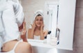 With white towel on a head. In the bathroom. Woman in white towel in head have care of herself Royalty Free Stock Photo