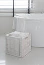 White towel in wooden basket with modern bath tub Royalty Free Stock Photo