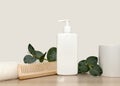 White towel wooden comb green eucalyptus branch. White shampoo.
