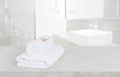 White towels on table in defocused bathroom with copy space Royalty Free Stock Photo