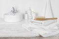 White towels on wooden table over blurred simple bathroom background