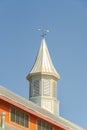 White tower and weather vane at the roof of a barn at a vinyard against blue sky Royalty Free Stock Photo