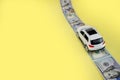 White toy car on money road on yellow background with copy space Royalty Free Stock Photo