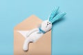 White toy hare sewn from fabric in paper envelope with letter or postcard. Studio shot of flat lay, mail, communication and Royalty Free Stock Photo