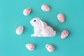 White toy neon rabbit with a eggs candy. Festive easter layout.