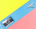 Toy plane and camera on blue and yellow pink background Royalty Free Stock Photo