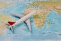 White toy plane on the world map background