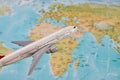 White toy plane on the world map background