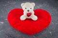 White toy teddy bear with heart on a gray background. The symbol Royalty Free Stock Photo