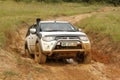White Toyota Triton DHD crossing mud obstacle Royalty Free Stock Photo