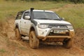 White Toyota Triton DHD crossing mud obstacle Royalty Free Stock Photo